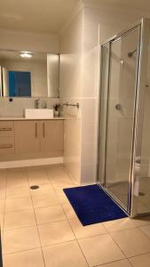 a bathroom with a shower and a blue rug at Centro Gungahlin in Harrison