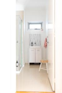 a white bathroom with a sink and a window at Elwood Star- Beachside Retreat in Melbourne