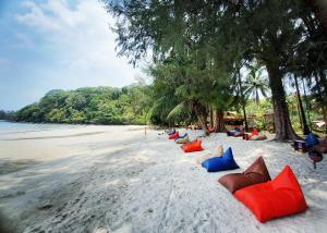 una fila de coloridas sillas de playa en una playa de arena en Koh Kood Club en Ko Kood