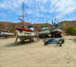 a group of boats sitting on a sandy beach at PUNTA VELEROS ROOFTOP in Los Órganos