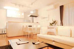 sala de estar con sofá blanco y mesa en ファミリア・デザインハウス札幌, en Sapporo