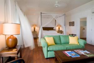 a living room with a green couch and a bed at The Atlantis Historic Inn in Saint Joseph +29 photos