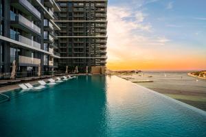 uma piscina com cadeiras em frente a um edifício em *Private Beach* Best Ocean View Emaar BeachFront no Dubai