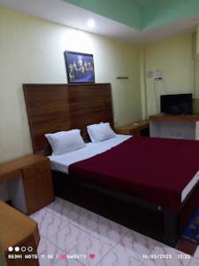 sypialnia z dużym łóżkiem z drewnianym zagłówkiem w obiekcie Hotel Swagat Bhubaneswar w mieście Bhubaneswar