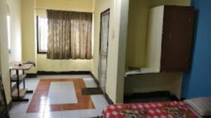a room with a bed and a table and a window at HOTEL STEP IN Bhubaneswar in Bhubaneshwar