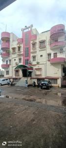 a large building with cars parked in a parking lot at HOTEL STEP IN Bhubaneswar in Bhubaneshwar