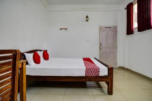 a bedroom with a bed with red pillows on it at OYO Flagship Aruvi Annex in Munnar