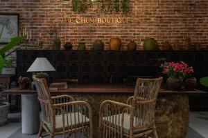 two chairs sitting at a table in front of a brick wall at The Chum Boutique in Hue