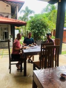 a group of people sitting around a table at Hiriketiya New Radiant House in Dickwella