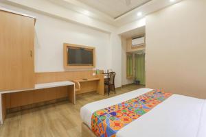 een hotelkamer met een bed en een flatscreen-tv bij FabHotel Raghubar Kripa in Lucknow