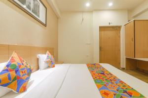 Un dormitorio con una cama con almohadas de colores. en FabHotel Raghubar Kripa en Lucknow