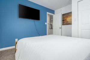 a bedroom with a bed and a tv on a blue wall at Centrally Located 3BD Urban Oasis in Indianapolis