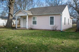 a white house with a tree in a yard at Centrally Located 3BD Urban Oasis in Indianapolis