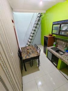 una pequeña cocina con una mesa y una escalera en Fifa Homestay & Villa 2BR, en Tanjungkarang