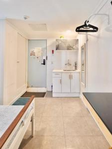 a kitchen with white cabinets and a sink at Seoul Mansion Guesthouse in Seoul