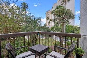 a balcony with a table and chairs and palm trees at Universal-Disney Dream Studio 2 - The Enclave in Orlando