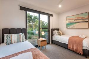 two beds in a room with a window at Eagle Rise Plus Studio in Dunsborough +28 photos