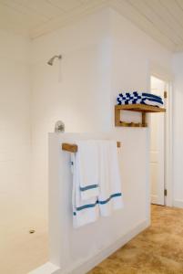 a white bathroom with blue and white towels on a wall at The Atlantis Historic Inn in Saint Joseph