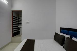 um quarto com uma cama e um corredor em OYO HOTEL KAVYA RESIDENCY em Alīgarh