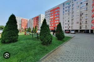 a park with trees and a bench in a city at Apartament modern Ared UTA in Arad