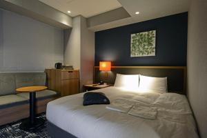 a hotel room with a bed and a chair at Hotel Forza Osaka Kitahama in Osaka +104 photos