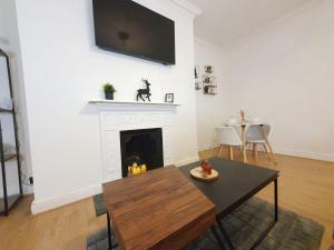 sala de estar con chimenea y TV en la pared en Hyde Park Elegance Escape : Central & Cozy, en Londres