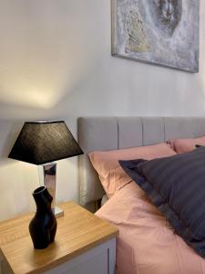 a bedroom with a bed and a lamp on a table at Hyde Park Elegance Escape : Central & Cozy in London