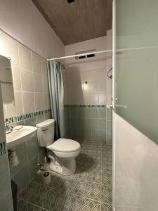 a bathroom with a toilet and a sink and a shower at Brisa del Mar #2 in Brisas de Zicatela