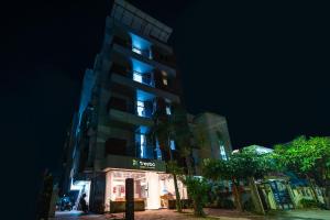 a tall building with blue lights on it at night at Treebo Trend Silver Apartment in Dhantoli