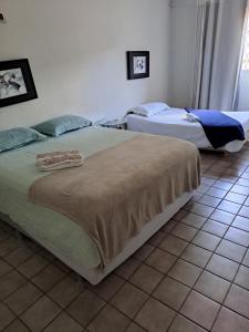 two beds in a room with a tiled floor at Casa aconchegante na zona leste in Teresina