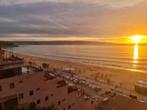 a view of the beach at sunset at Departamento primera línea frente al mar in Viña del Mar