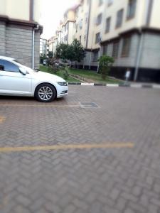 a white car parked in a parking lot at Tranquil haven - spacious, cozy, 1 bedroom in Kisumu