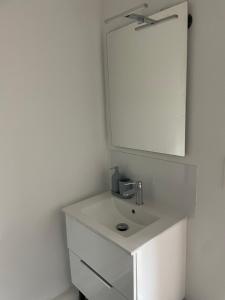 a white bathroom with a sink and a mirror at Studio 303 - Hyper Centre - Intégralement rénové - Toutes commodités à pied in Saint-Nazaire