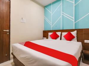 1 dormitorio con 1 cama grande con almohadas rojas en OYO Hotel 56 INDORI, en Indore