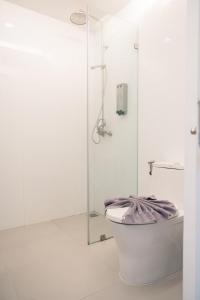 a white bathroom with a shower and a toilet at BearPacker Patong Hostel in Patong Beach