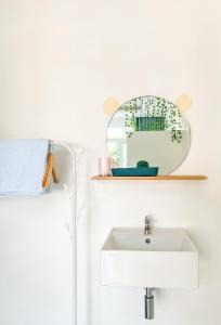 une salle de bain avec un lavabo et un miroir dans l'établissement HY GUESTHOUSE PHU QUOC - Nhà Hy vivu bên Vườn, à Duong Dong 17 autres photos