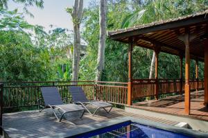 zwei Stühle auf einer Terrasse neben einem Pool in der Unterkunft Ubud Heaven Sayan in Ubud