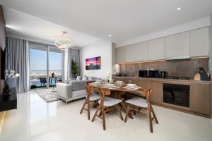 een keuken en een woonkamer met een tafel en stoelen bij *Private Beach* Best Ocean View Emaar BeachFront in Dubai