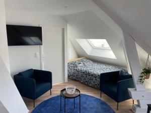 Un dormitorio con una cama y dos sillas y una mesa. en Studio 302 - Hyper Centre - Intégralement rénové - Toutes commodités à pied, en Saint-Nazaire