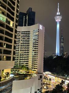 - une vue sur une ville la nuit avec une aiguille d'espace dans l'établissement Mercu Summer Suite KLCC by Kuminshu, à Kuala Lumpur