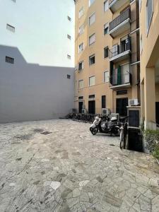 Un estacionamiento con motocicletas estacionadas frente a un edificio. en Bilocale Lambrate/Città Studi, en Milán