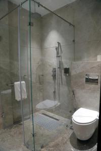 a bathroom with a glass shower with a toilet at peninsula the boutique hotel in Panchkula