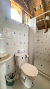 La salle de bains est pourvue de toilettes blanches et d'un lavabo. dans l'établissement La Greca - Casa de Paz, à San Agustín