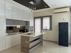 a kitchen with white cabinets and a blue refrigerator at Bichrome Marina Island Private Villa Pangkor Lumut in Lumut