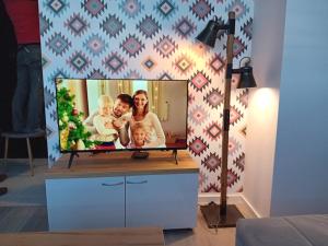 a television with a picture of a family on it at Vučko II in Bjelašnica