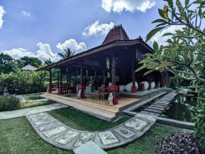 a pavilion with tables and chairs in a garden at Ubud Heaven Penestanan in Ubud