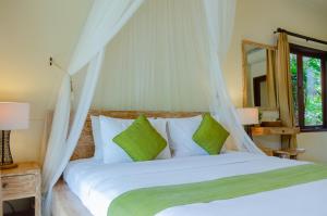- une chambre avec un grand lit blanc et un miroir dans l'établissement Ubud Heaven Penestanan, à Ubud