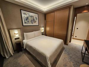 een slaapkamer met een groot wit bed en 2 verlichting bij Address Residences Opera District Downtown Dubai Burj Khalifa in Dubai