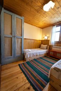 a bedroom with two beds and a wooden ceiling at Kandaphery Guest Houses in Miykovtsi