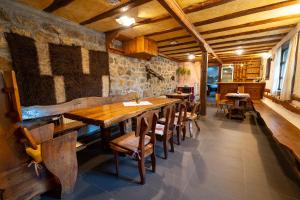 Kandaphery Guest Houses في Miykovtsi: غرفة طعام مع طاولات وكراسي خشبية
